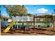 Community playground featuring a slide, swings, and a nearby tennis court at 4450 47Th W Ave # 202, Bradenton, FL 34210