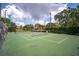 Outdoor tennis court surrounded by lush greenery and mature trees at 4450 47Th W Ave # 202, Bradenton, FL 34210