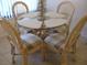Dining area with glass-top table and four wicker chairs at 4450 47Th W Ave # 202, Bradenton, FL 34210