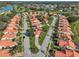 Aerial view of a well-maintained neighborhood featuring lakes, mature trees, and red tile roofs at 4989 Clubview E Ct, Bradenton, FL 34203