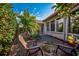 Intimate backyard sitting area with stone pavers and two chairs surrounded by mature tropical landscaping at 4989 Clubview E Ct, Bradenton, FL 34203