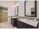 Stylish bathroom with dual vanities, decorative mirror, and a glass-enclosed shower at 4989 Clubview E Ct, Bradenton, FL 34203
