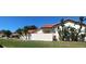 Stylish home exterior featuring private courtyard area, tile roof, and lush tropical landscaping at 4989 Clubview E Ct, Bradenton, FL 34203
