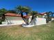 Beautiful home exterior featuring manicured lawn, stone features, and partial privacy wall at 4989 Clubview E Ct, Bradenton, FL 34203