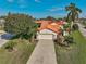 Home exterior with a lush lawn, driveway, a mature tree, and a white exterior color scheme at 4989 Clubview E Ct, Bradenton, FL 34203