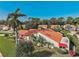 Beautiful villa with a red tile roof surrounded by lush landscaping and mature trees on a sunny day at 4989 Clubview E Ct, Bradenton, FL 34203