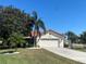 Charming single-story home with a red tile roof, lush landscaping, and a wide driveway at 4989 Clubview E Ct, Bradenton, FL 34203
