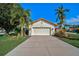 Inviting home with a well-maintained lawn, tropical landscaping, and a two-car garage at 4989 Clubview E Ct, Bradenton, FL 34203