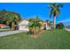 Inviting single-story home with a well-kept lawn, lush landscaping, and a freshly painted white exterior at 4989 Clubview E Ct, Bradenton, FL 34203