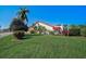 Well-maintained front lawn with mature landscaping and a single-story home featuring a red tile roof at 4989 Clubview E Ct, Bradenton, FL 34203