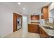 Bright kitchen with stainless steel refrigerator, granite counters, wood cabinets, and tile floors at 4989 Clubview E Ct, Bradenton, FL 34203