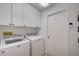 Bright laundry room featuring a modern washer and dryer set, and ample cabinet space for storage at 4989 Clubview E Ct, Bradenton, FL 34203