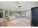 Bright sunroom features many windows, ceiling fan, and neutral finishes with a light colored sofa at 4989 Clubview E Ct, Bradenton, FL 34203