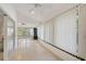 Bright sunroom with tile flooring, white walls, vertical blinds, and sliding doors at 4989 Clubview E Ct, Bradenton, FL 34203
