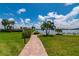 Brick walkway leading to waterfront with lush landscaping and gazebo at 9011 Midnight Pass Rd # 228, Sarasota, FL 34242