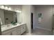 Bright bathroom featuring dual sinks, vanity and large mirror at 1590 Royal Rd, Venice, FL 34293