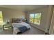 Cozy bedroom with a queen bed, stylish bedside tables, and a sunny window at 1590 Royal Rd, Venice, FL 34293