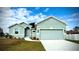 Charming one-story house with a light teal exterior, two-car garage, and landscaped lawn at 1590 Royal Rd, Venice, FL 34293