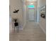 Inviting hallway with neutral tones, light tile flooring and artful decor at 1590 Royal Rd, Venice, FL 34293