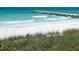 White sand beach with ocean waves and pier in the background at 106 11Th S St # A, Bradenton Beach, FL 34217
