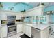 Modern kitchen with stainless steel appliances and breakfast bar overlooking the pool at 7812 Broadmoor Pines Blvd, Sarasota, FL 34243