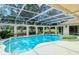 Inviting pool area with covered patio, spa, and lush landscaping at 7812 Broadmoor Pines Blvd, Sarasota, FL 34243