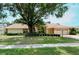 Single-story home with a large tree and manicured lawn at 7812 Broadmoor Pines Blvd, Sarasota, FL 34243
