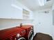 Laundry room with red washer and dryer and white cabinets at 3603 N Point Rd # 202, Osprey, FL 34229