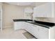 Kitchen with white cabinets and black countertops at 4063 Caddie E Dr, Bradenton, FL 34203