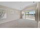 Inviting living room with sliding glass doors leading to a sunroom and views of a tranquil lake at 4063 Caddie E Dr, Bradenton, FL 34203