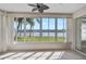 Enclosed sunroom features multiple windows showcasing serene lake and lush tropical landscape views at 4063 Caddie E Dr, Bradenton, FL 34203