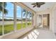 Relaxing sunroom with serene lake views visible through the expansive windows and palm trees at 4063 Caddie E Dr, Bradenton, FL 34203