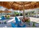 Seating area with thatched roof umbrellas and picnic tables at 376 Aruba Cir # 301, Bradenton, FL 34209