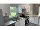 Modern kitchen with white cabinets, stainless steel appliances, and gray countertops at 11261 3Rd Ave, Punta Gorda, FL 33955