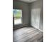 Well-lit bedroom, featuring wood-look floors and a double door closet at 11261 3Rd Ave, Punta Gorda, FL 33955
