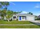 Newly renovated light blue house with a blue door, and a well-manicured lawn at 3875 Pan American Blvd, North Port, FL 34287