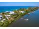 Aerial view of waterfront property with private dock and lush landscaping at 426 N Casey Key Rd, Osprey, FL 34229