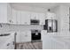 White shaker cabinets, stainless steel appliances and geometric backsplash at 200 Redwood Rd, Rotonda West, FL 33947