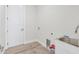 Laundry room with a stainless steel sink and white cabinetry at 200 Redwood Rd, Rotonda West, FL 33947