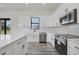 Modern kitchen with white cabinets, stainless steel appliances and quartz countertops at 200 Redwood Rd, Rotonda West, FL 33947