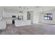 Open concept kitchen with white cabinets, island, and gray wood-look floors at 200 Redwood Rd, Rotonda West, FL 33947