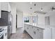 Open concept kitchen with white cabinets, large island and gray flooring at 200 Redwood Rd, Rotonda West, FL 33947