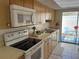Kitchen features white appliances and access to patio at 6201 Green View Dr # 130, Sarasota, FL 34231