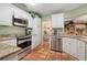 Modern kitchen with white cabinets, granite counters, and stainless steel appliances at 1713 North Dr, Sarasota, FL 34239
