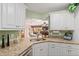 Modern kitchen with white cabinets, granite countertops, and stainless steel appliances at 1713 North Dr, Sarasota, FL 34239