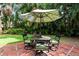 Relaxing patio furniture under umbrella in lush garden setting at 1713 North Dr, Sarasota, FL 34239