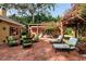 Relaxing brick patio with seating area, fire pit, and pergola at 1713 North Dr, Sarasota, FL 34239