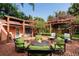 Brick patio with pergola, fire pit, and green seating at 1713 North Dr, Sarasota, FL 34239
