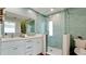 Modern bathroom with double vanity, glass shower, and light teal tile at 676 Key Royale Drive, Holmes Beach, FL 34217