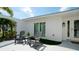 Relaxing front patio featuring two dark gray adirondack chairs and small potted plants at 676 Key Royale Drive, Holmes Beach, FL 34217